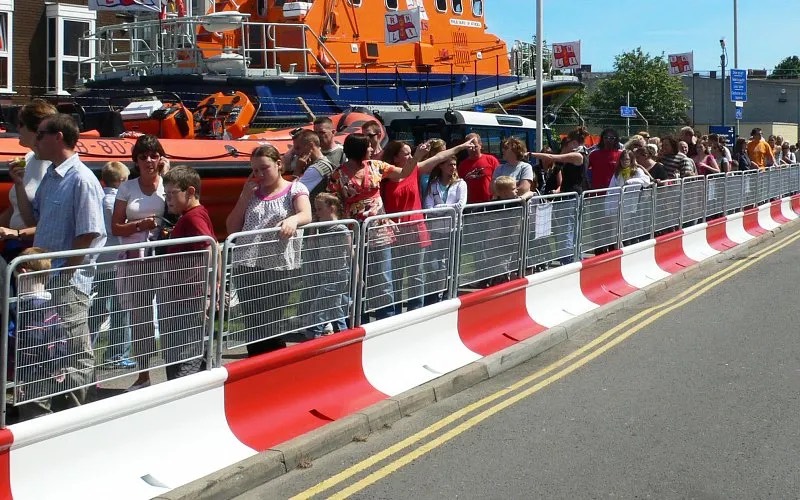 Crowd control barriers lining a street at a busy public event